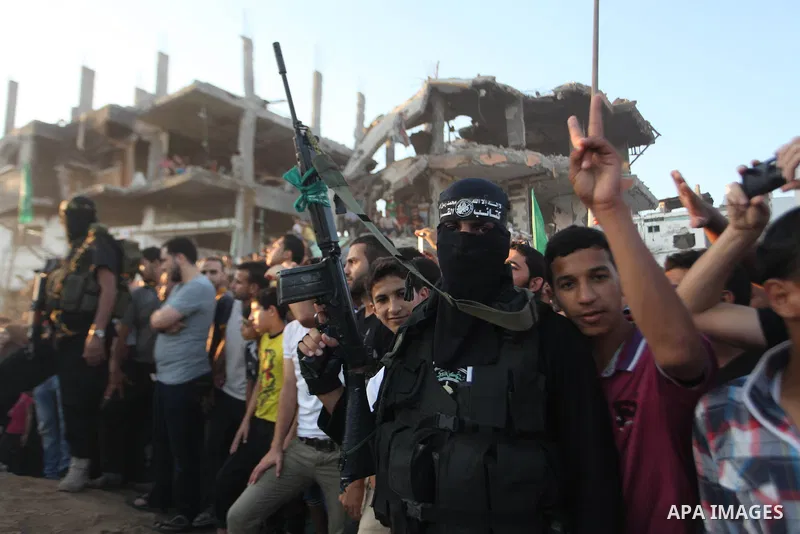 Palestinian militants of Izzedine al-Qassam Brigades, military wing of Hamas, and their supporters celebrate a victory rally at the debris of destroyed houses in Shijaiyah, neighborhood of Gaza City, in the northern Gaza...