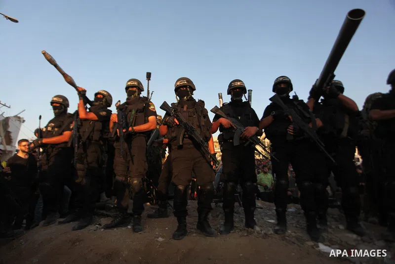 Palestinian militants of Izzedine al-Qassam Brigades, military wing of Hamas, and their supporters celebrate a victory rally at the debris of destroyed houses in Shijaiyah, neighborhood of Gaza City, in the northern Gaza...