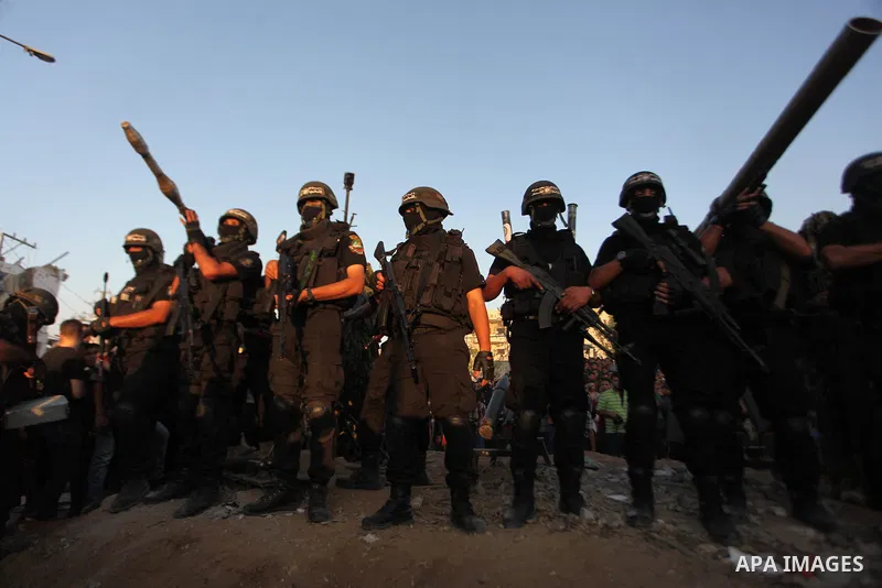 Palestinian militants of Izzedine al-Qassam Brigades, military wing of Hamas, and their supporters celebrate a victory rally at the debris of destroyed houses in Shijaiyah, neighborhood of Gaza City, in the northern Gaza...