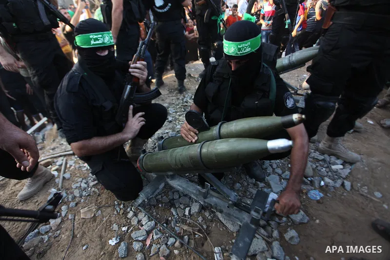 Palestinian militants of Izzedine al-Qassam Brigades, military wing of Hamas, and their supporters celebrate a victory rally at the debris of destroyed houses in Shijaiyah, neighborhood of Gaza City, in the northern Gaza...