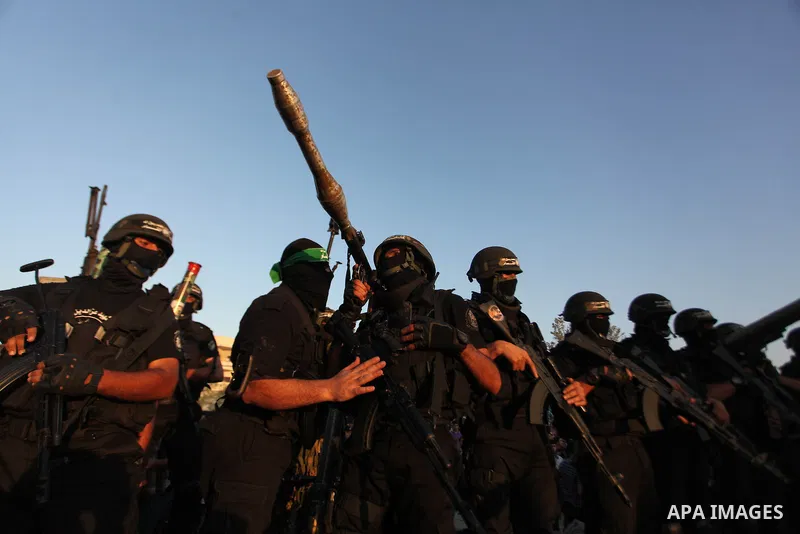 Palestinian militants of Izzedine al-Qassam Brigades, military wing of Hamas, and their supporters celebrate a victory rally at the debris of destroyed houses in Shijaiyah, neighborhood of Gaza City, in the northern Gaza...