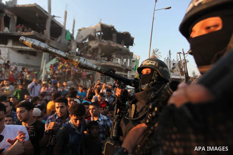 Palestinian militants of Izzedine al-Qassam Brigades, military wing of Hamas, and their supporters celebrate a victory rally at the debris of destroyed houses in Shijaiyah, neighborhood of Gaza City, in the northern Gaza...