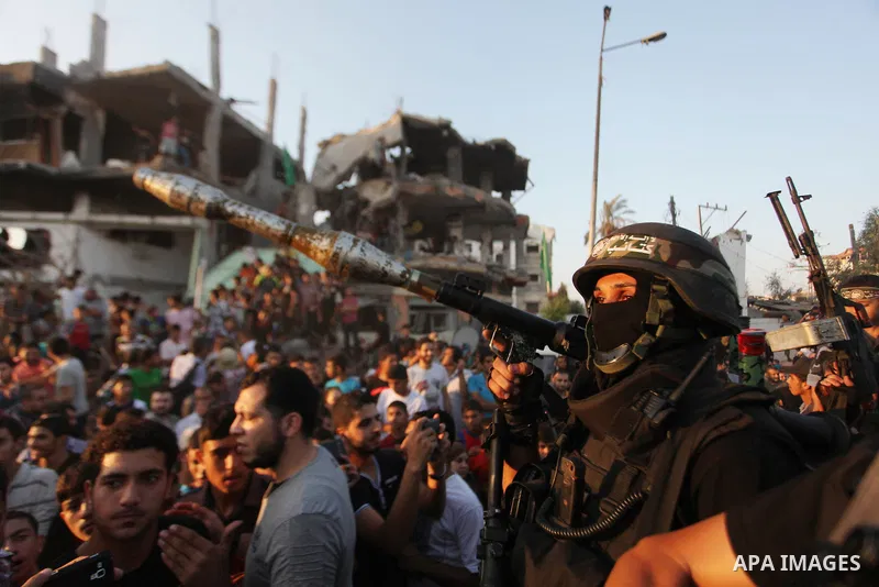 Palestinian militants of Izzedine al-Qassam Brigades, military wing of Hamas, and their supporters celebrate a victory rally at the debris of destroyed houses in Shijaiyah, neighborhood of Gaza City, in the northern Gaza...
