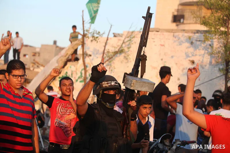 Palestinian militants of Izzedine al-Qassam Brigades, military wing of Hamas, and their supporters celebrate a victory rally at the debris of destroyed houses in Shijaiyah, neighborhood of Gaza City, in the northern Gaza...