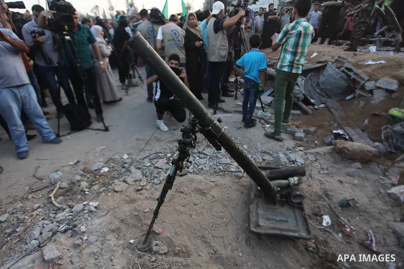 Palestinian militants of Izzedine al-Qassam Brigades, military wing of Hamas, and their supporters celebrate a victory rally at the debris of destroyed houses in Shijaiyah, neighborhood of Gaza City, in the northern Gaza...