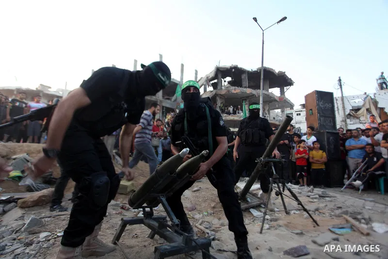 Palestinian militants of Izzedine al-Qassam Brigades, military wing of Hamas, and their supporters celebrate a victory rally at the debris of destroyed houses in Shijaiyah, neighborhood of Gaza City, in the northern Gaza...