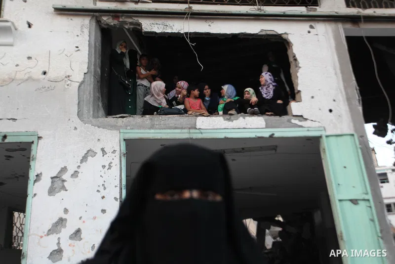 Palestinian militants of Izzedine al-Qassam Brigades, military wing of Hamas, and their supporters celebrate a victory rally at the debris of destroyed houses in Shijaiyah, neighborhood of Gaza City, in the northern Gaza...