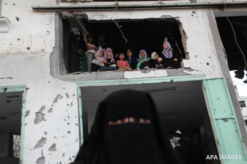 Palestinian militants of Izzedine al-Qassam Brigades, military wing of Hamas, and their supporters celebrate a victory rally at the debris of destroyed houses in Shijaiyah, neighborhood of Gaza City, in the northern Gaza...