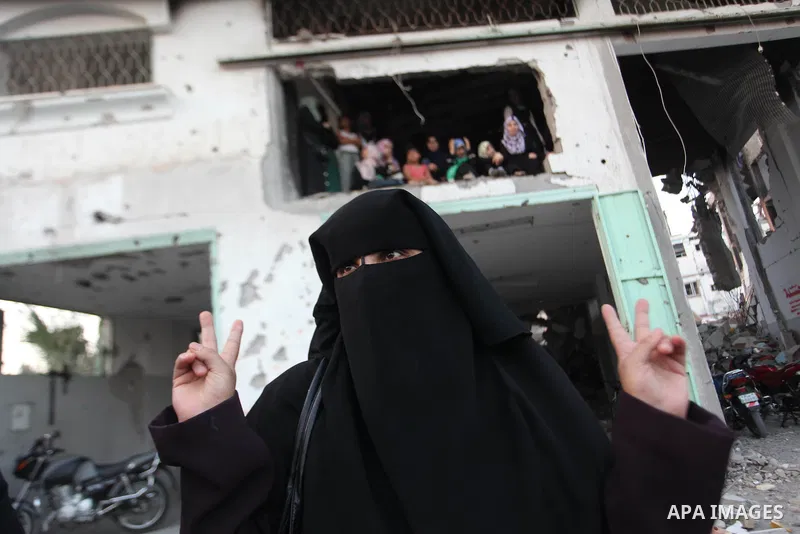 Palestinian militants of Izzedine al-Qassam Brigades, military wing of Hamas, and their supporters celebrate a victory rally at the debris of destroyed houses in Shijaiyah, neighborhood of Gaza City, in the northern Gaza...