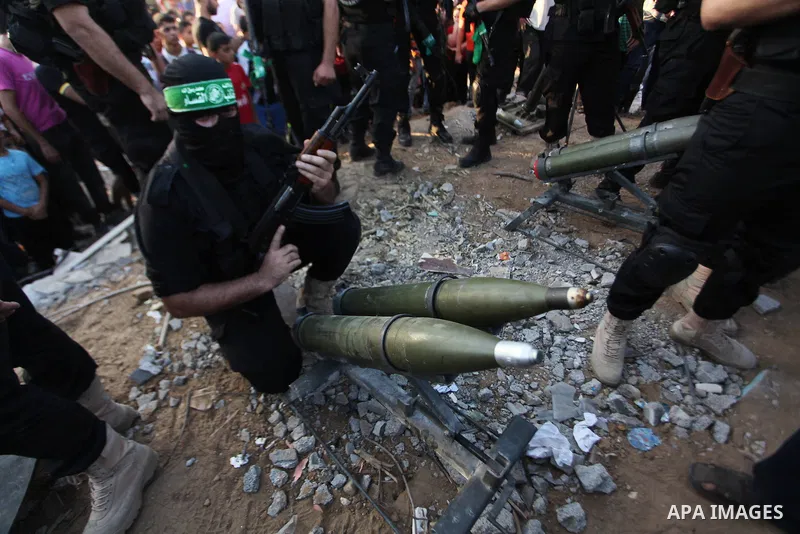 Palestinian militants of Izzedine al-Qassam Brigades, military wing of Hamas, and their supporters celebrate a victory rally at the debris of destroyed houses in Shijaiyah, neighborhood of Gaza City, in the northern Gaza...