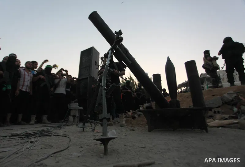 Palestinian militants of Izzedine al-Qassam Brigades, military wing of Hamas, and their supporters celebrate a victory rally at the debris of destroyed houses in Shijaiyah, neighborhood of Gaza City, in the northern Gaza...