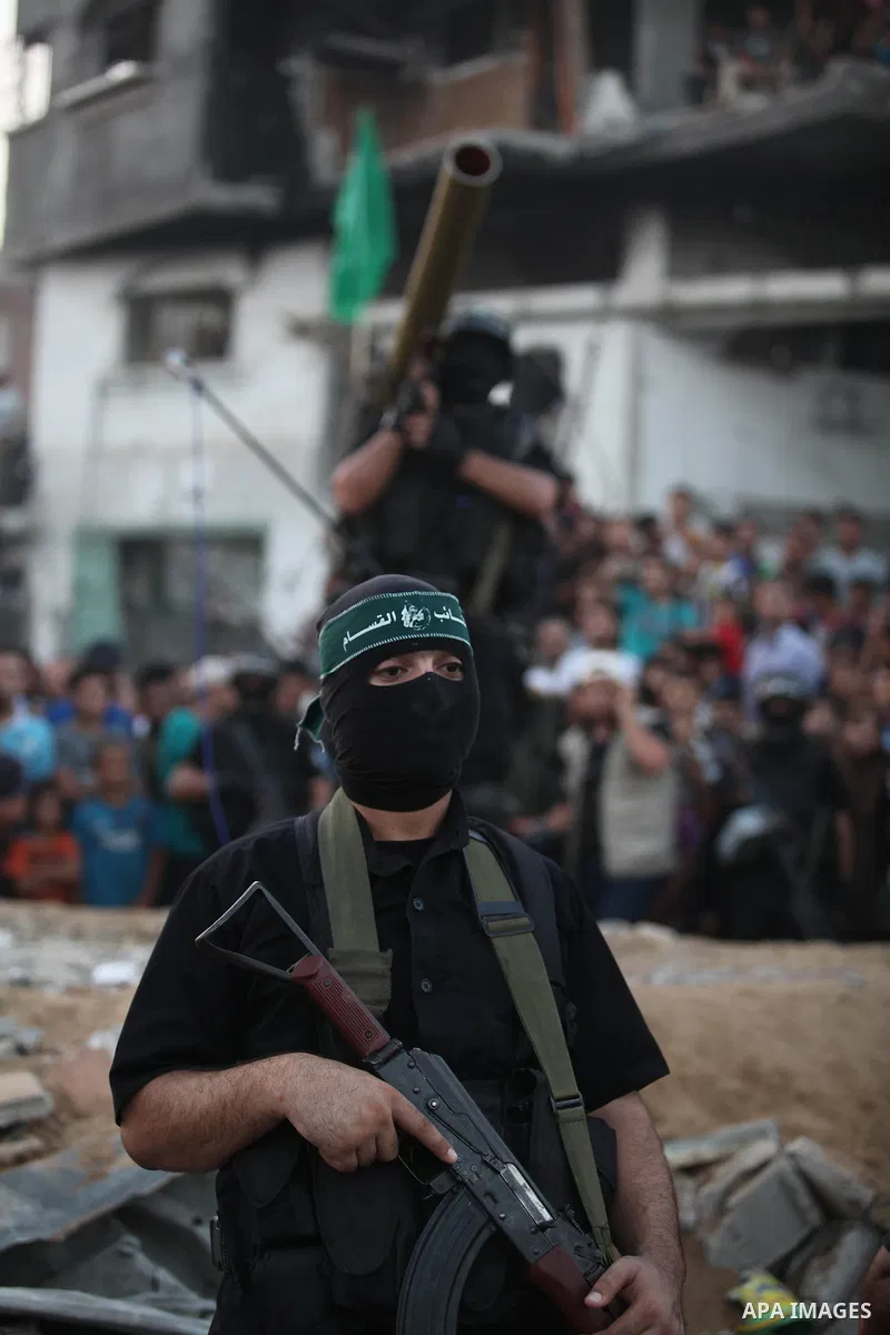 Palestinian militants of Izzedine al-Qassam Brigades, military wing of Hamas, and their supporters celebrate a victory rally at the debris of destroyed houses in Shijaiyah, neighborhood of Gaza City, in the northern Gaza...