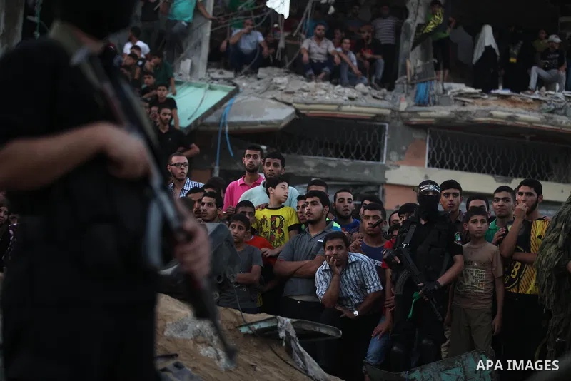 Palestinian militants of Izzedine al-Qassam Brigades, military wing of Hamas, and their supporters celebrate a victory rally at the debris of destroyed houses in Shijaiyah, neighborhood of Gaza City, in the northern Gaza...
