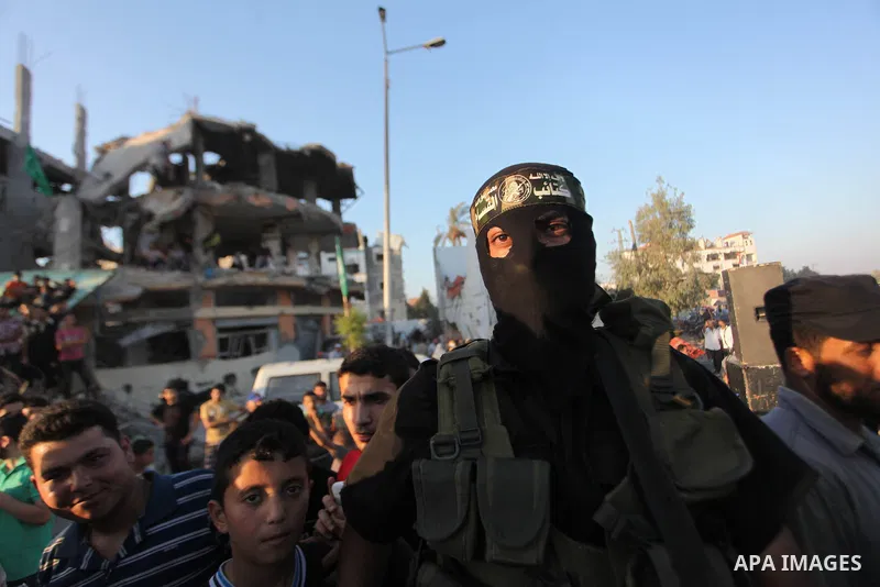 Palestinian militants of Izzedine al-Qassam Brigades, military wing of Hamas, and their supporters celebrate a victory rally at the debris of destroyed houses in Shijaiyah, neighborhood of Gaza City, in the northern Gaza...
