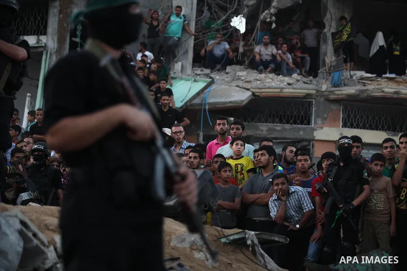Palestinian militants of Izzedine al-Qassam Brigades, military wing of Hamas, and their supporters celebrate a victory rally at the debris of destroyed houses in Shijaiyah, neighborhood of Gaza City, in the northern Gaza...