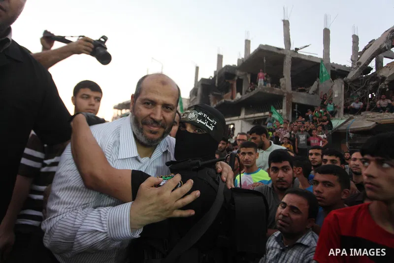 Palestinian militants of Izzedine al-Qassam Brigades, military wing of Hamas, and their supporters celebrate a victory rally at the debris of destroyed houses in Shijaiyah, neighborhood of Gaza City, in the northern Gaza...