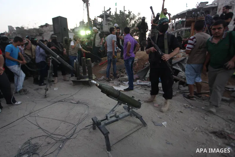 Palestinian militants of Izzedine al-Qassam Brigades, military wing of Hamas, and their supporters celebrate a victory rally at the debris of destroyed houses in Shijaiyah, neighborhood of Gaza City, in the northern Gaza...
