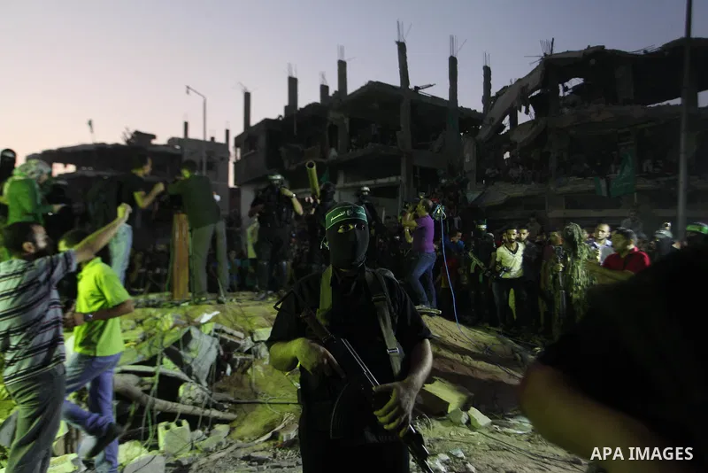 Palestinian militants of Izzedine al-Qassam Brigades, military wing of Hamas, and their supporters celebrate a victory rally at the debris of destroyed houses in Shijaiyah, neighborhood of Gaza City, in the northern Gaza...