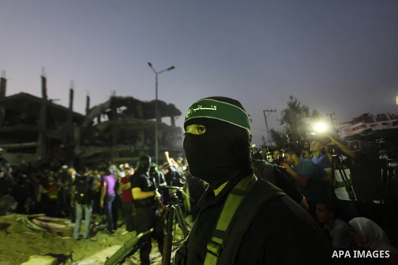 Palestinian militants of Izzedine al-Qassam Brigades, military wing of Hamas, and their supporters celebrate a victory rally at the debris of destroyed houses in Shijaiyah, neighborhood of Gaza City, in the northern Gaza...