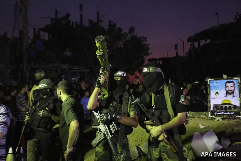 Palestinian militants of Izzedine al-Qassam Brigades, military wing of Hamas, and their supporters celebrate a victory rally at the debris of destroyed houses in Shijaiyah, neighborhood of Gaza City, in the northern Gaza...