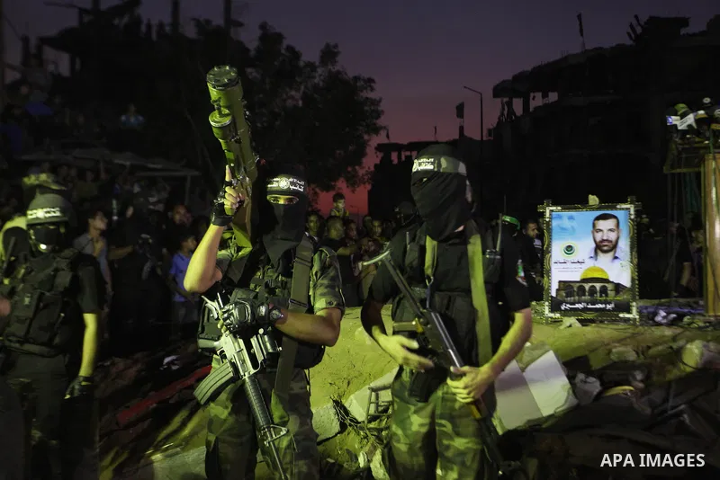 Palestinian militants of Izzedine al-Qassam Brigades, military wing of Hamas, and their supporters celebrate a victory rally at the debris of destroyed houses in Shijaiyah, neighborhood of Gaza City, in the northern Gaza...