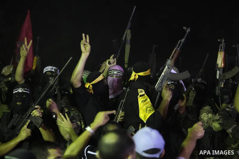 Palestinian militants of Izzedine al-Qassam Brigades, military wing of Hamas, and their supporters celebrate a victory rally at the debris of destroyed houses in Shijaiyah, neighborhood of Gaza City, in the northern Gaza...