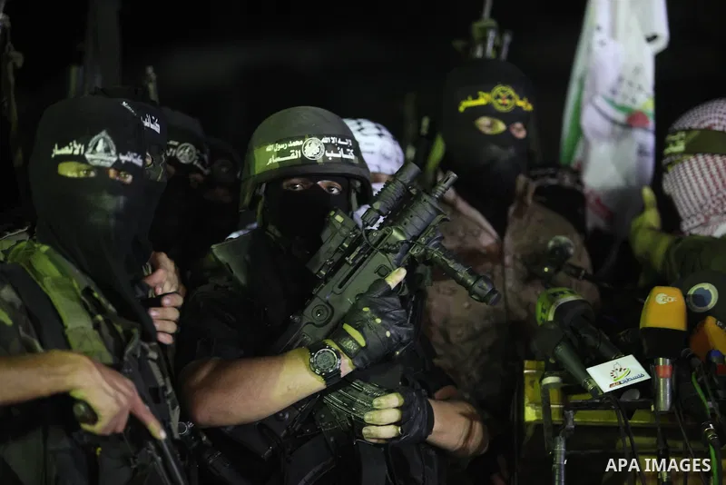 Palestinian militants of Izzedine al-Qassam Brigades, military wing of Hamas, and their supporters celebrate a victory rally at the debris of destroyed houses in Shijaiyah, neighborhood of Gaza City, in the northern Gaza...