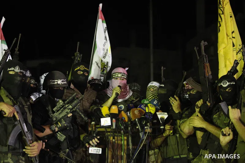 Palestinian militants of Izzedine al-Qassam Brigades, military wing of Hamas, and their supporters celebrate a victory rally at the debris of destroyed houses in Shijaiyah, neighborhood of Gaza City, in the northern Gaza...