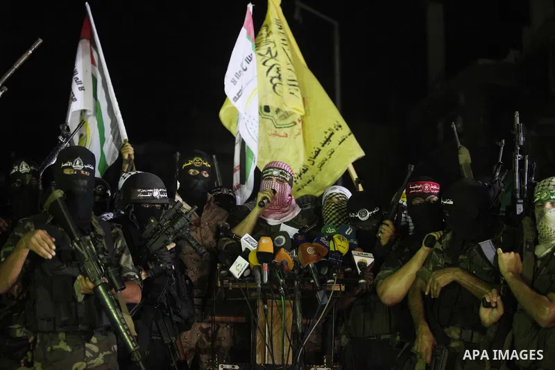 Palestinian militants of Izzedine al-Qassam Brigades, military wing of Hamas, and their supporters celebrate a victory rally at the debris of destroyed houses in Shijaiyah, neighborhood of Gaza City, in the northern Gaza...