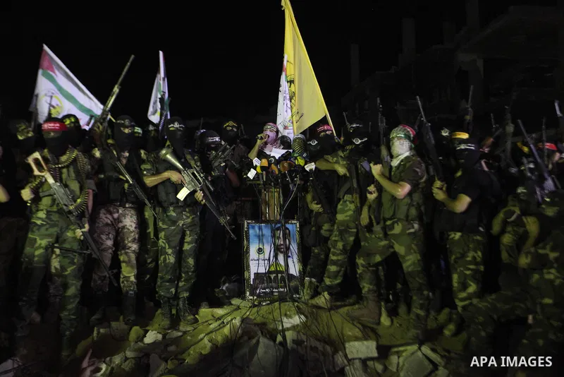 Palestinian militants of Izzedine al-Qassam Brigades, military wing of Hamas, and their supporters celebrate a victory rally at the debris of destroyed houses in Shijaiyah, neighborhood of Gaza City, in the northern Gaza...