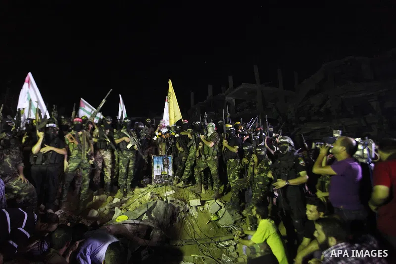 Palestinian militants of Izzedine al-Qassam Brigades, military wing of Hamas, and their supporters celebrate a victory rally at the debris of destroyed houses in Shijaiyah, neighborhood of Gaza City, in the northern Gaza...
