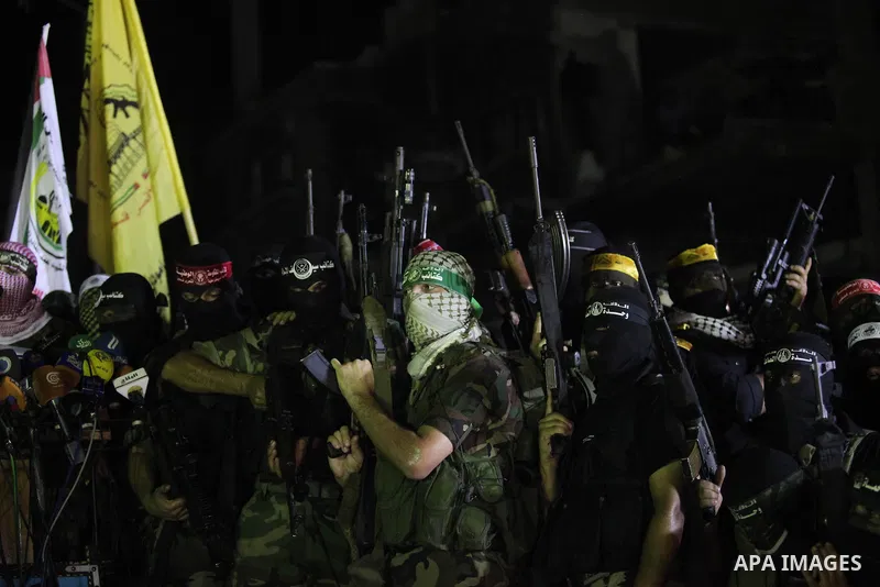 Palestinian militants of Izzedine al-Qassam Brigades, military wing of Hamas, and their supporters celebrate a victory rally at the debris of destroyed houses in Shijaiyah, neighborhood of Gaza City, in the northern Gaza...