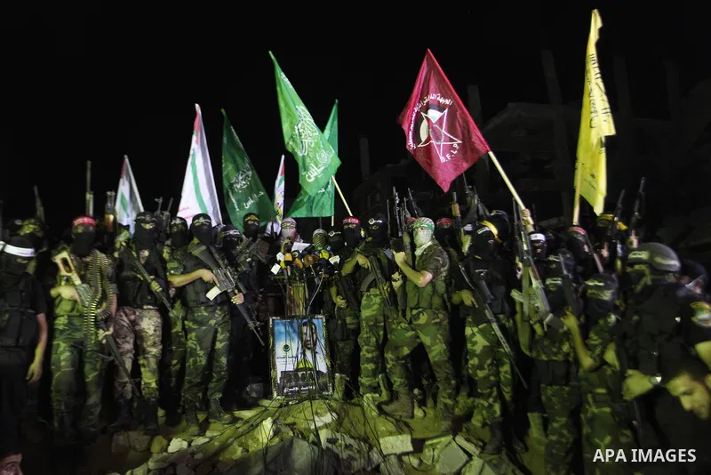 Palestinian militants of Izzedine al-Qassam Brigades, military wing of Hamas, and their supporters celebrate a victory rally at the debris of destroyed houses in Shijaiyah, neighborhood of Gaza City, in the northern Gaza...