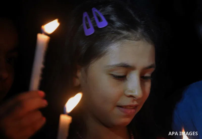 Palestinian Families hold candles during a protest in front of the remains El Zafer Tower destroyed in an israeli airstrike, in Gaza city, on Aug. 27, 2014. The open-ended ceasefire in the Gaza war between Israel and the...
