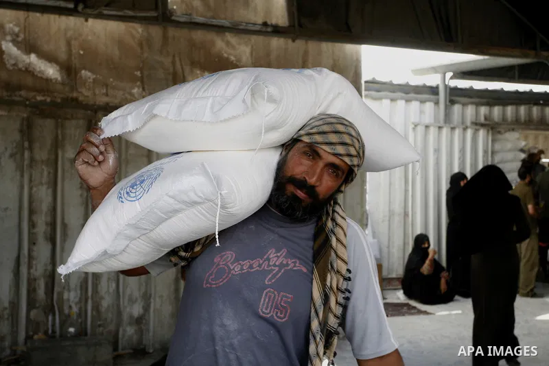 A Palestinian man receives food supplies from a distribution centre of the United Nations Relief and Works Agency (UNRWA) in Rafah in southern Gaza strip on August 28, 2014. The aid was sent to the U.N. office to be dist...