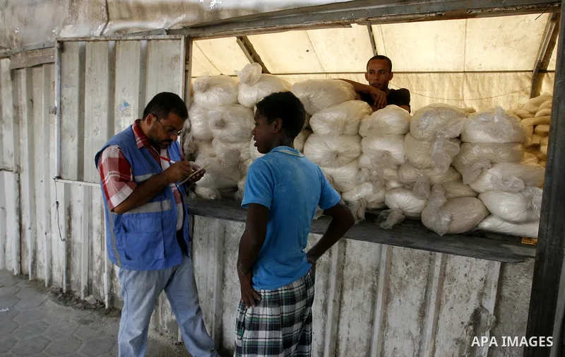 Palestinians wait to receive food supplies from a distribution centre of the United Nations Relief and Works Agency (UNRWA) in Rafah in southern Gaza strip on August 28, 2014. The aid was sent to the U.N. office to be di...
