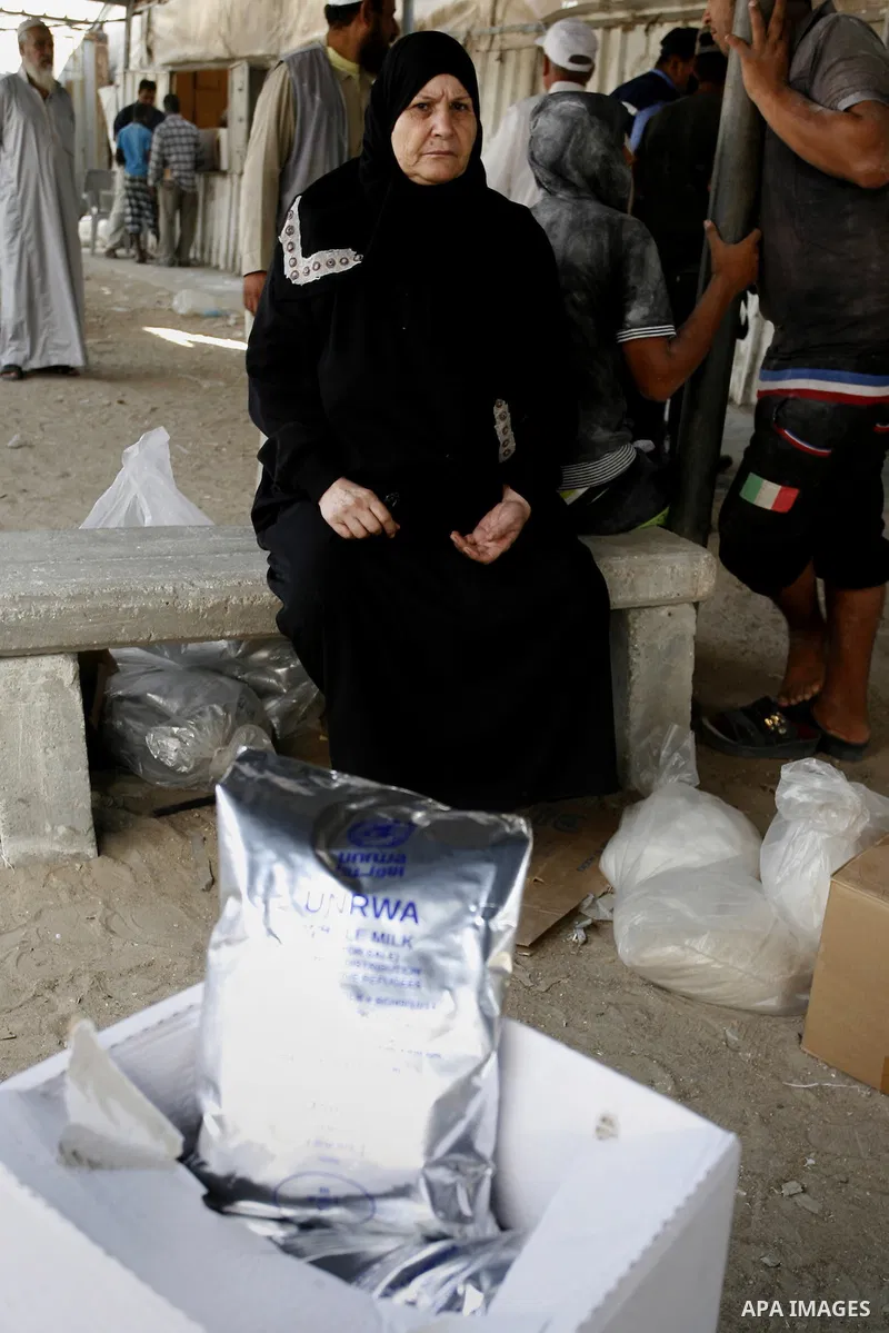 Palestinians wait to receive food supplies from a distribution centre of the United Nations Relief and Works Agency (UNRWA) in Rafah in southern Gaza strip on August 28, 2014. The aid was sent to the U.N. office to be di...
