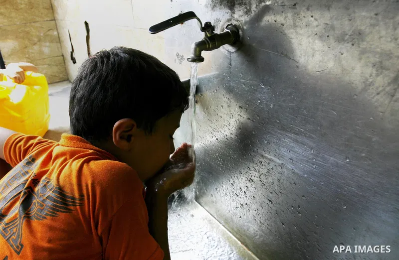 Palestinians children fill plastic bottles and water containers with drinking water from a public tap in Rafah in the southern Gaza Strip on August 28, 2014. Israel and Palestinians both boasted of victory in the Gaza wa...
