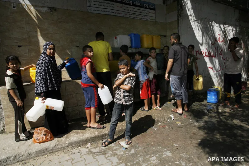 Palestinians children fill plastic bottles and water containers with drinking water from a public tap in Rafah in the southern Gaza Strip on August 28, 2014. Israel and Palestinians both boasted of victory in the Gaza wa...