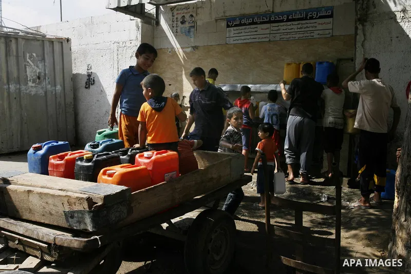 Palestinians children fill plastic bottles and water containers with drinking water from a public tap in Rafah in the southern Gaza Strip on August 28, 2014. Israel and Palestinians both boasted of victory in the Gaza wa...
