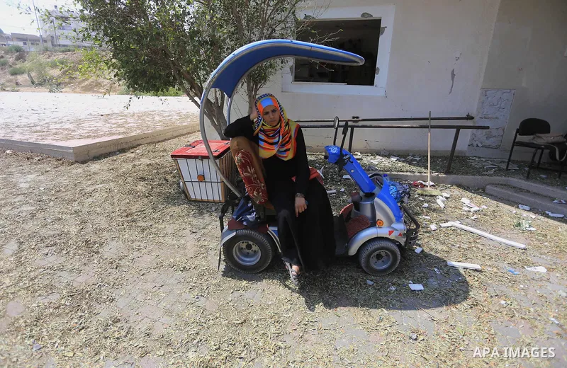A Palestinian disabled woman sits on a chair as she takes part a rally in front of a rehabilitation centre, in Gaza city August 28, 2014. Israel and Palestinians both boasted of victory in the Gaza war but analysts say H...