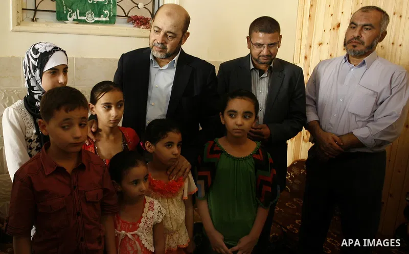 Hamas political leader Moussa Abu Marzouk visits the mourning tent of senior Hamas commander Mohammed Abu Shammala (seen in posters), who was killed by an Israeli air strike during the seven-week Israeli offensive, in Ra...