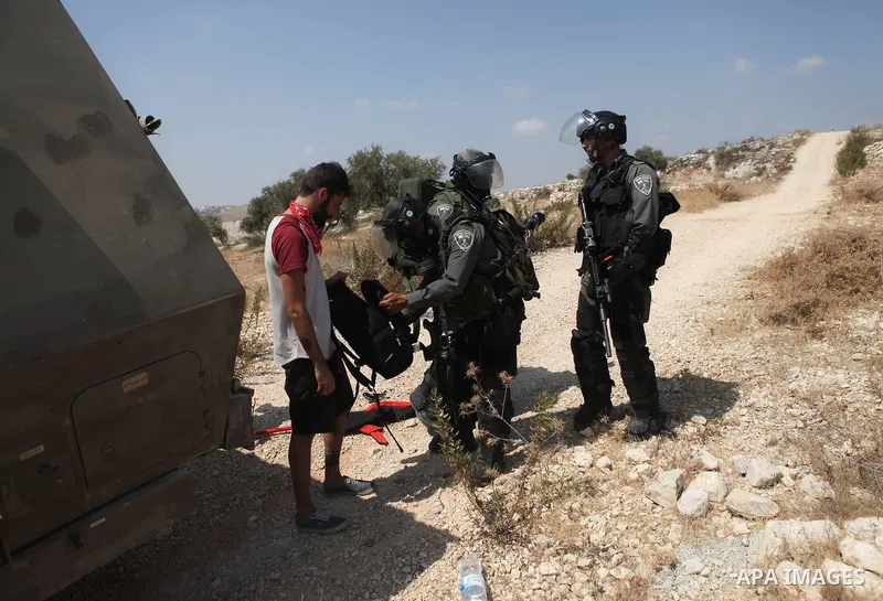 Members of the Israeli security forces arrest an Israeli demonstrating in solidarity with Palestinian protestors in the village of Bilin, near the West Bank city of Ramallah following a march in support of the resistance...
