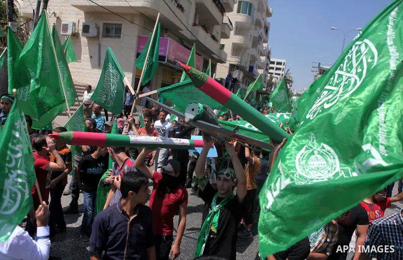 Palestinian boys hold a mock rocket during a rally following the Friday prayers, three days after a deal hailed by Israel and Hamas as 'victory' in the 50-day war on August 29, 2014 in the West Bank town of Hebron. Thous...