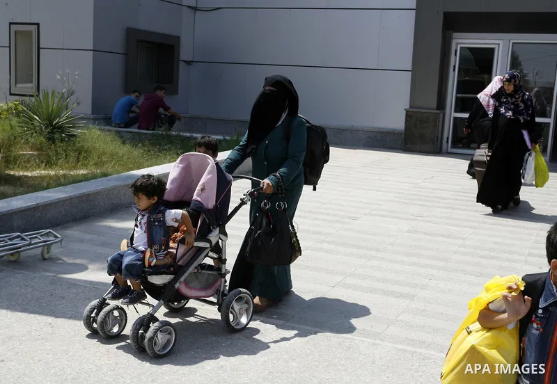 A Palestinian mother wheels his son as they wait to be given the permission to cross into Egypt at the Rafah border crossing in the southern Gaza Strip, on August 28, 2014. The Rafah crossing with Egypt is Gaza's only ga...