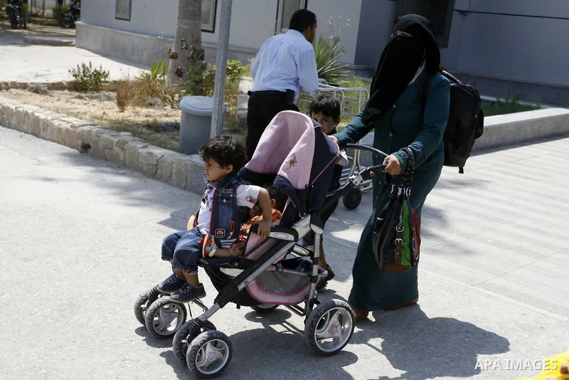 A Palestinian mother wheels his son as they wait to be given the permission to cross into Egypt at the Rafah border crossing in the southern Gaza Strip, on August 28, 2014. The Rafah crossing with Egypt is Gaza's only ga...