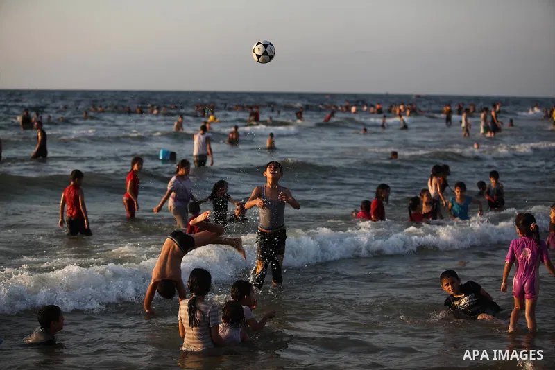 Palestinians swim in the Mediterranean Sea off the coast of Gaza City August 29, 2014, days after a ceasefire was reached. An open-ended ceasefire, mediated by Egypt, took effect on Tuesday evening. It called for an inde...