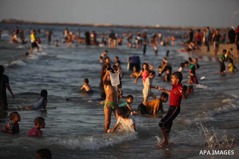 Palestinians swim in the Mediterranean Sea off the coast of Gaza City August 29, 2014, days after a ceasefire was reached. An open-ended ceasefire, mediated by Egypt, took effect on Tuesday evening. It called for an inde...