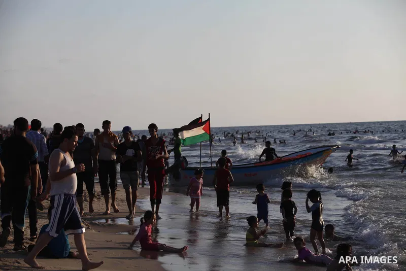 Palestinians swim in the Mediterranean Sea off the coast of Gaza City August 29, 2014, days after a ceasefire was reached. An open-ended ceasefire, mediated by Egypt, took effect on Tuesday evening. It called for an inde...