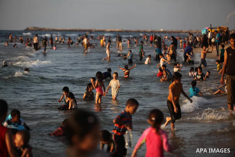 Palestinians swim in the Mediterranean Sea off the coast of Gaza City August 29, 2014, days after a ceasefire was reached. An open-ended ceasefire, mediated by Egypt, took effect on Tuesday evening. It called for an inde...